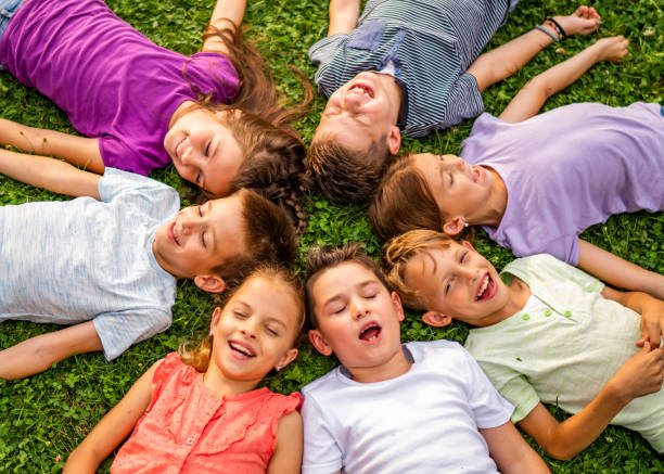 istock View above group of children lying down on the grass 994308156