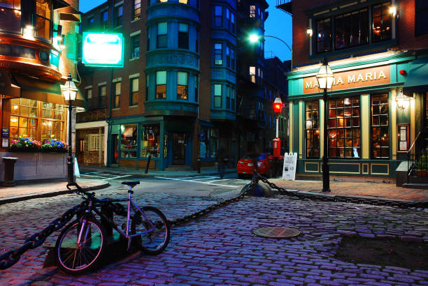 A silent calm falls upon Momma Maria's Italian Restaurant and Boston's North End Boston, MA, USA April 25, 2011 A lone bike is chained to a fence on an unusually quiet night in Boston's Italian North End north end boston photos stock pictures, royalty-free photos & images