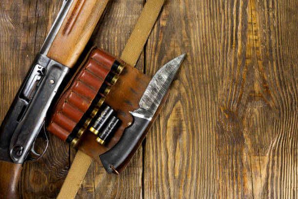 istock Hunting rifle and ammunition lie on wooden background. Copy space 994314640