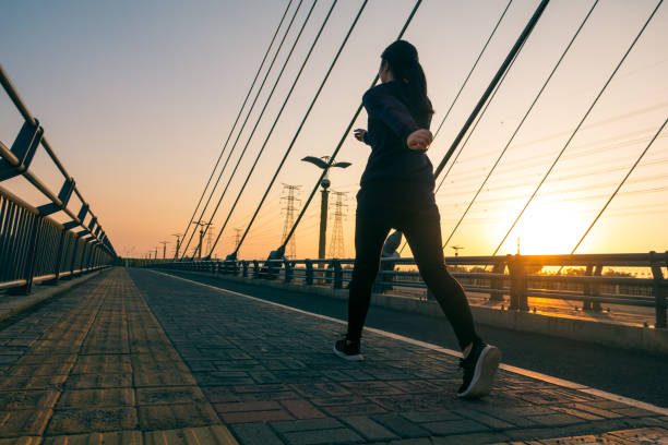 mujer caminando al aire libre con luz solar - cámara lenta fotografías e imágenes de stock