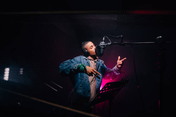 Young hipster African-American rapper recording songs in music recording studio Young fashionable hip hop singer singing and recording music in professional music recording studio hip hop stock pictures, royalty-free photos & images