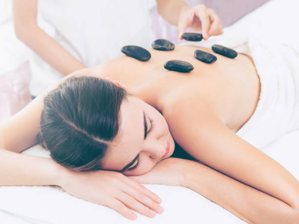 istock Hot stone massage treatment by therapist in spa. 994318860