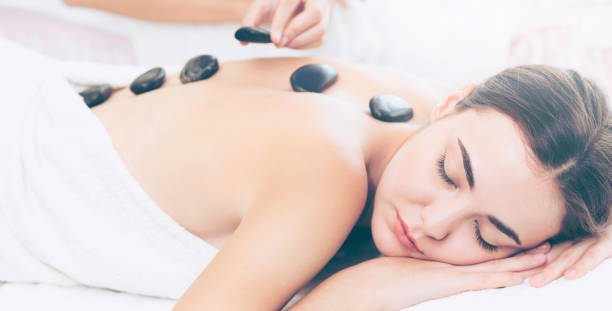 istock Hot stone massage treatment by therapist in spa. 994318874