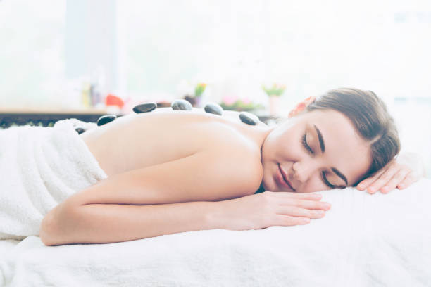 istock Hot stone massage treatment by therapist in spa. 994318972