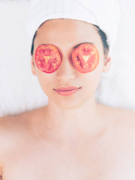 istock Woman getting eye nature treatment by tomato. 994319148