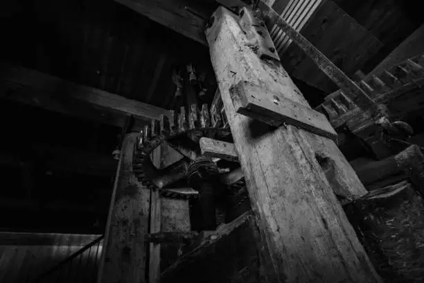 Old Traditional grinder (Mill), made of wood and stone. Shoot inside in black and white (B&W). In focus are huge cogwheels and handles. Shoot in Zealand in Denmark, Scandinavia, Europe.