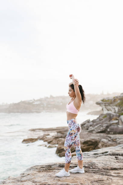 istock Fit Woman Stretching on Rocks Hands in Air 994324466