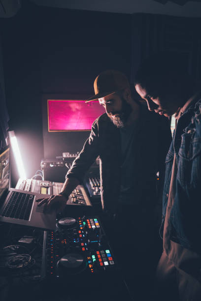 Hipster music producer and singer working together in recording studio stock photo
