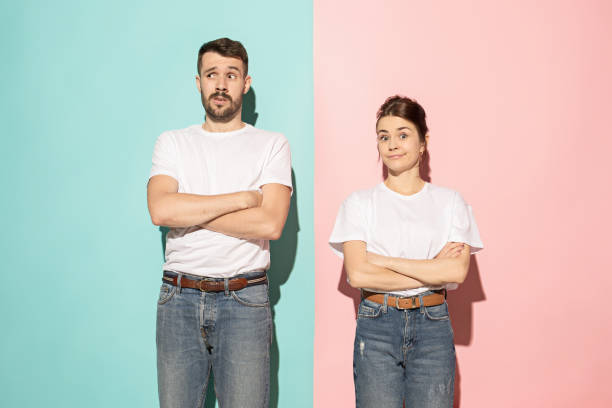 istock Let me think. Doubtful pensive couple with thoughtful expression making choice against pink background 994346156
