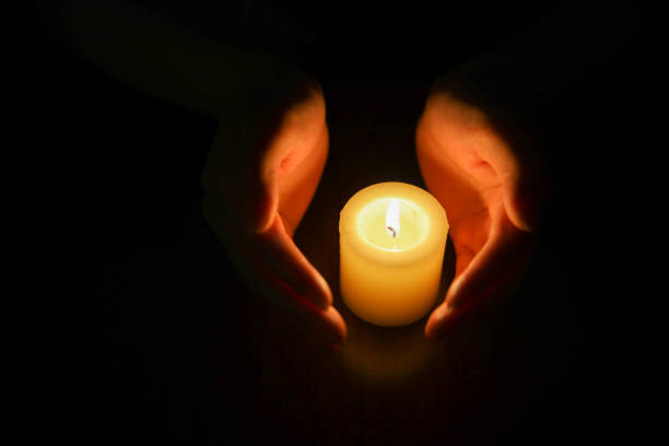 istock Hands protecting burning candle candlelight in darkness 994350332