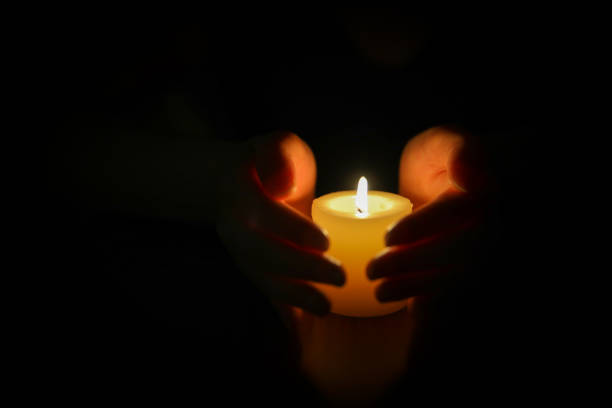 istock Hands protecting burning candle candlelight in darkness 994352226