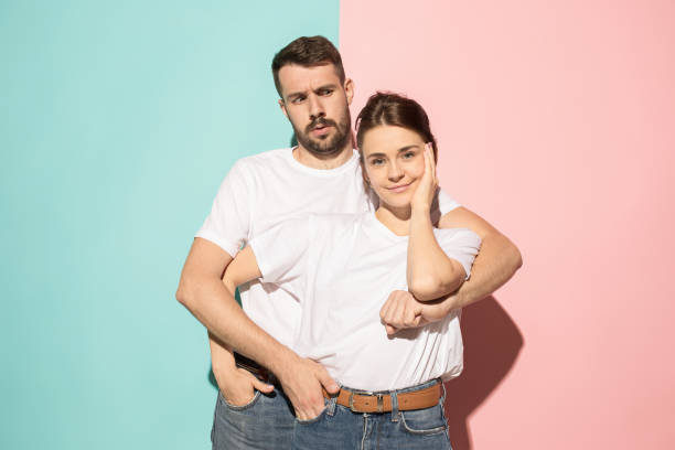 istock Wow. Doubtful pensive couple with thoughtful expression making choice against pink background 994354060