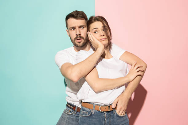 istock Wow. Doubtful pensive couple with thoughtful expression making choice against pink background 994358682