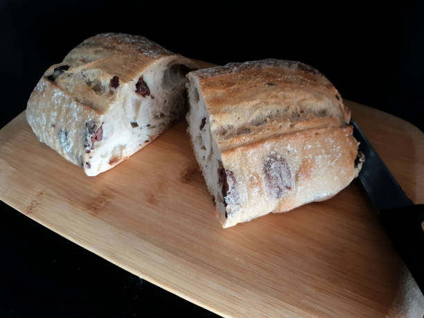 istock Sliced Ciabatta bread on wooden board exposed on black background 994358736
