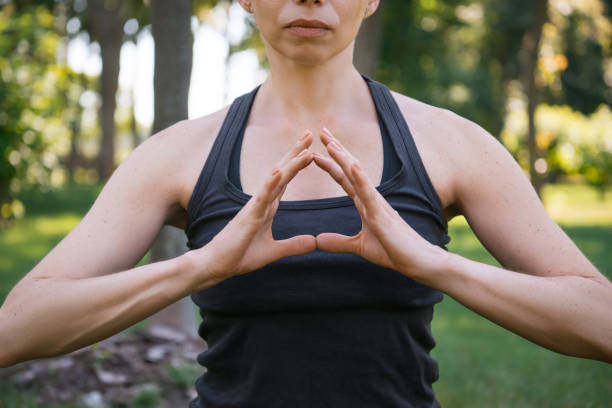 istock cropped image of woman meditating and making gesture with hands in park 994364346