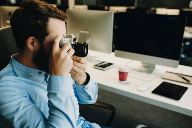 istock Man taking picture with camera in office 994377892
