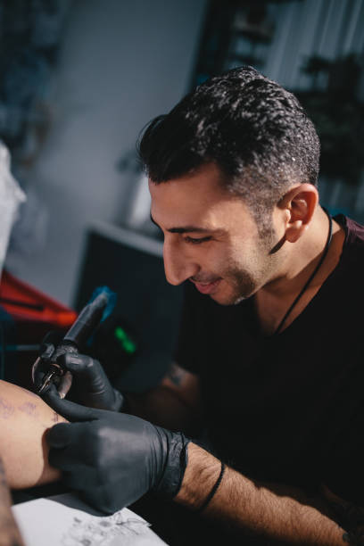 istock Smiling tattoo artist working on tattoo design in tattoo studio 994383486