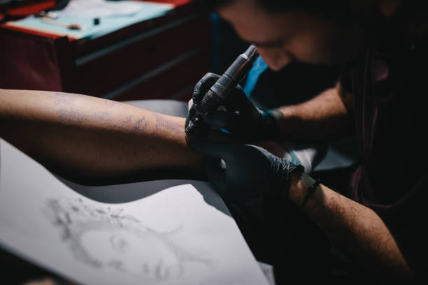 istock Tattoo artist working with tattoo machine in professional tattoo studio 994387542