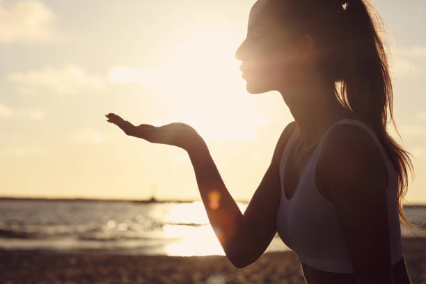 istock Silhouette young woman practicing yoga on the beach at sunset 994403884