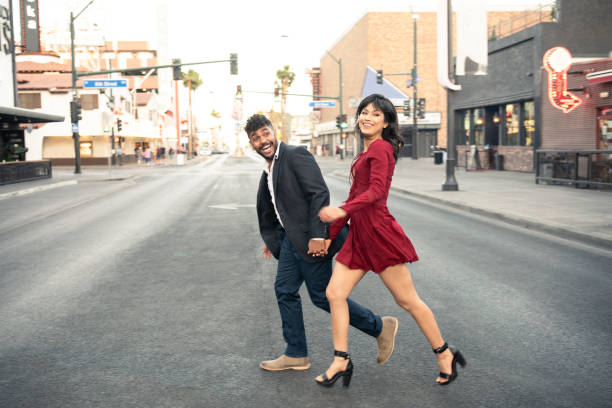 istock Young couple crossing road holding hands 994424980
