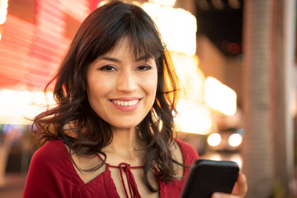 Cheerful young woman holding mobile phone