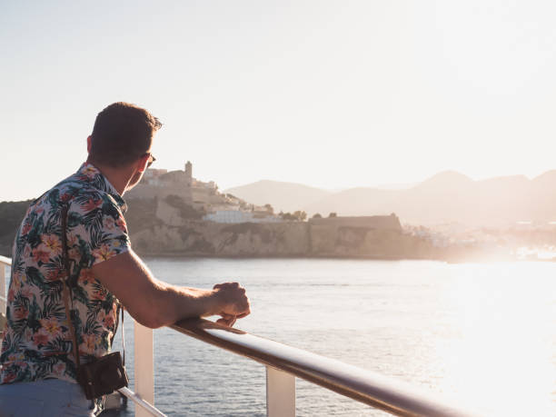 istock Attractive guy with a vintage camera on the deck of a cruise ship 994440636