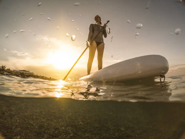istock Woman in wetsuit with a paddle board 994465380