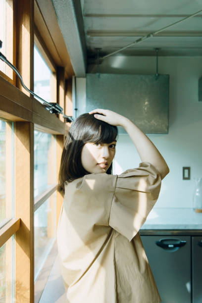 istock young woman standing a window. 994471306