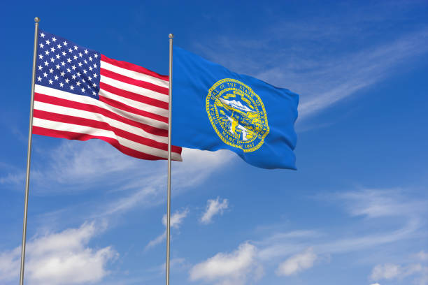 istock USA and Nebraska flags over blue sky background. 3D illustration 994476378