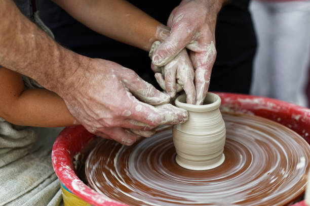 руки крупным планом гончара и его молодого ученика - making craft craftsperson circle стоковые фото и изображения