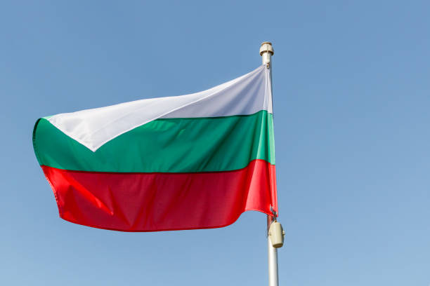 istock Waving flag of Bulgaria against blue sky with copy space on left 994485492