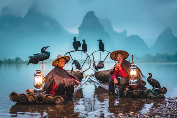 traditional chinese fishermen taking a break on bamboo raft - yangshuo imagens e fotografias de stock