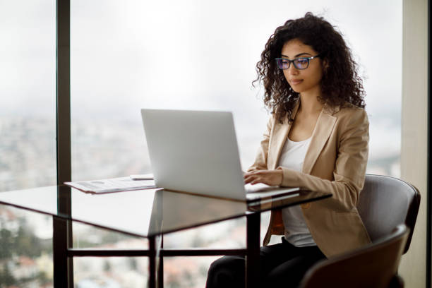 istock Businesswoman working on laptop at a cafe 994518590