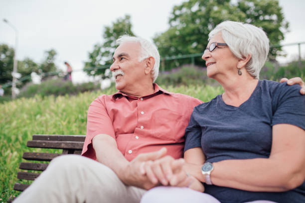 istock Senior couple holding hands while sitting on the bench 994527830