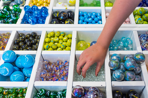 Colorful shelf full of balls from different sports.