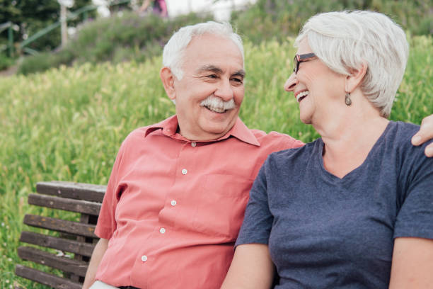 istock Old couple hugging and smiling while sitting on the bench 994531144