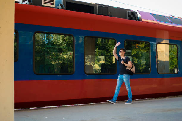 istock Young passenger running to catch the train at railroad station 994552034