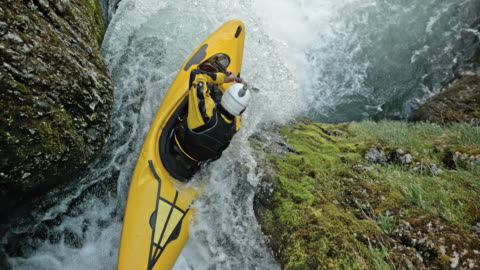 SLO MO Whitewater kayaker em um caiaque amarelo caindo de uma cachoeira