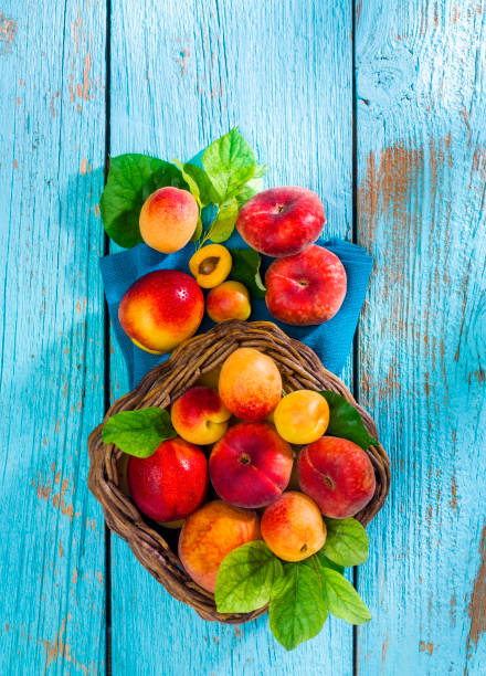 sommerfrüchte auf alten blau aus holz - peach nectarine fruit portion stock-fotos und bilder