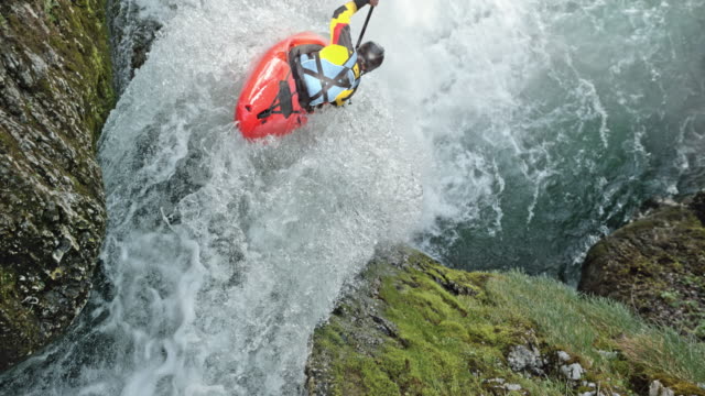 SLO MO Rider in a yellow whitewater kayak dropping a waterfall