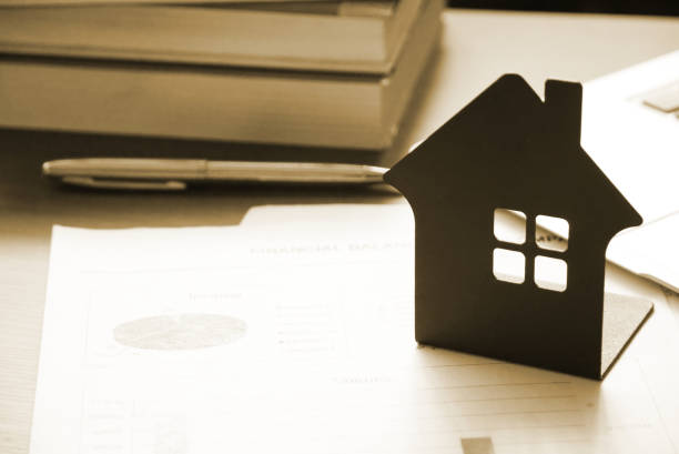 istock Yellow theme house model on document with background stack of book on the table. finance concept. 994631212