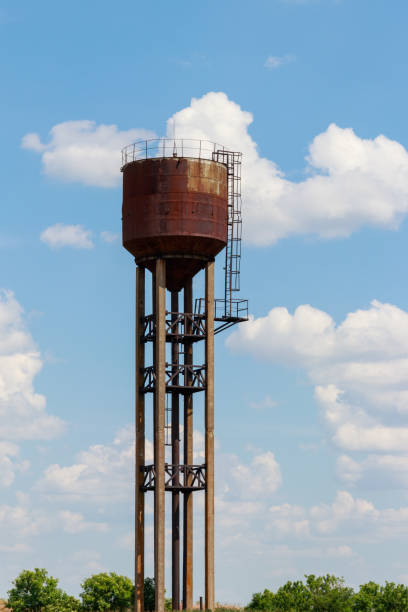 istock Old rusty water tower in the green field 994632304