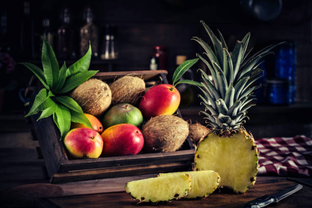 istock Wooden crates with assorted tropical fruits in rustic kitchen. Natural lighting 994641980
