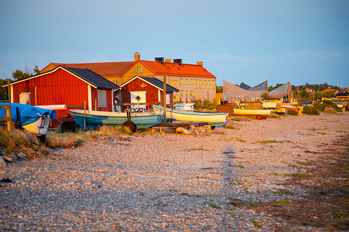 Fishing boat and fishing on the stony beach at sunset light in Sweden