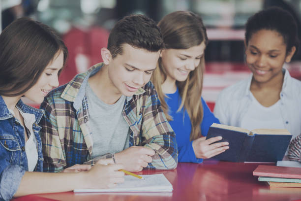 istock Teenagers Sitting at Table and Doing Homework. 994645368