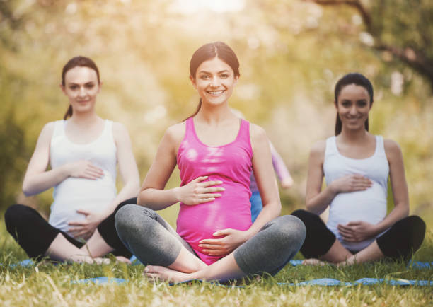 istock Pregnant Women Practicing Yoga in Summer Park. 994645528