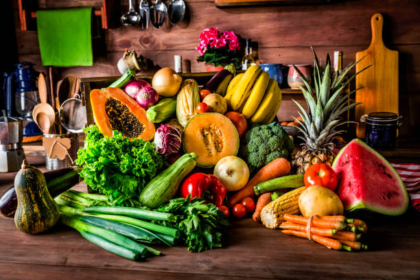istock Rustic kitchen with ready to cut and process organic tropical fruits and vegetables. Natural lighting 994645708