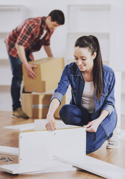 istock Young Couple Assembling Furniture in New Home. 994645974
