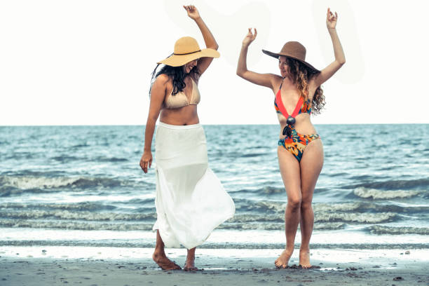 istock Happy women dance on sand beach in summer. 994646198