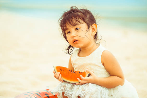 istock Adorable kid eating watermelon on the beach. 994646224